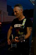 Anthony playing black Takamine acoustic guitar in the band: "The Sacred Hearts"