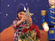 Lucia putting a star on the Christmas Tree