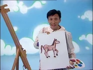 Jeff holding a painting of a pony