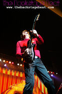 Murray playing his red Maton electric guitar in "Rove Live"