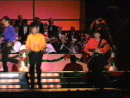 Murray playing red Takamine acoustic EF325SRC guitar on "Carols in the Domain"