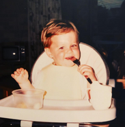 Lachy sitting in a highchair