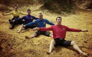 The Wiggles gliding their arms in a sandy area