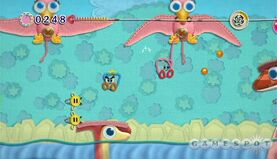 Kirby and Prince Fluff "play around" in Dino Jungle of Hot Land. Those yellow things are Buttonbees.