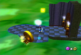 Mario on a platform in the Matter Splatter Area. A Question Block can be seen above the floor, as well as a Key closer in the foreground.