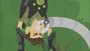 The robotic arm is pinching Chris's nose.