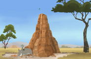 There's a warthog beside the termite mound.