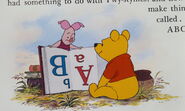 Piglet and Pooh Bear are both reading and learning a book about ABC's that's upside down