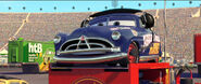 Doc Hudson watching Lightning McQueen drift.