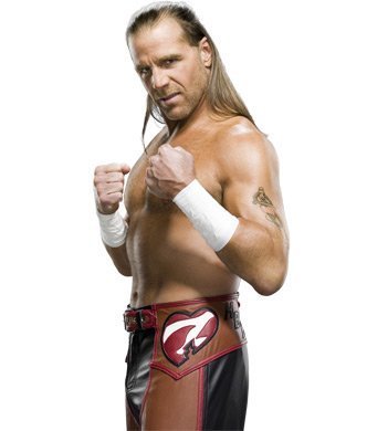 Shawn Michaels holds his fists up, wearing black and red pants and no shirt.