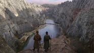 Two men overlook a valley encampment