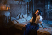 Episode 202: "Selene" sits on her and Rand's bed at the inn.
