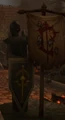 A statue with a shield showing the symbol in the Scarlet Monastery.