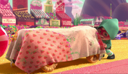 Vanellope rolls the Likkity-Split in to the racetrack, covered by a tarp.