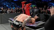 Orton suplexes Nakamura onto the announce table