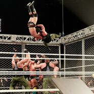 Strong chases Cole to the top of the structure and suplexes Cole onto a plethora of Superstars