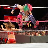 Asuka pushes Emma off the ring apron