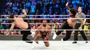 The Usos delivering a superkick to Big E