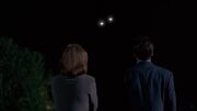 Fox Mulder and Dana Scully watch two lights