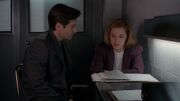 Fox Mulder shows Dana Scully fake newspaper