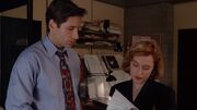 Fox Mulder shows Dana Scully paperwork