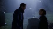 Fox Mulder and Dana Scully stand in rain