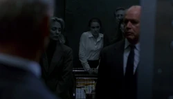  sees people shaded in gray and steps out of the elevator.