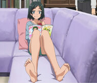 Komachi enjoying a piece of jam covered toast while reading a magazine.