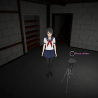 Ayano junto a una videocámara en el sótano