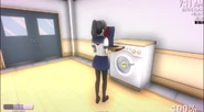 Ayano placing a Rain Coat in the washing machine.