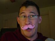 Markiplier wearing the pink mustache.