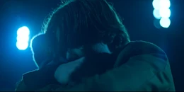 Wilhelm is hugging Simon on the football field.