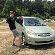 MrBeast kicking Tyler's old car, which he destroyed in a video.