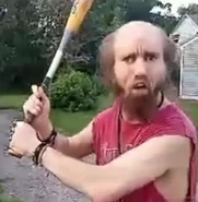 Cyraxx holding a baseball bat as he prepares to fight a protesting troll.