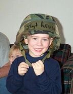 Austin as a toddler wearing a military hat (1999).