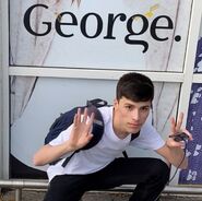 George posing in front of a wall with the word "George" on it.