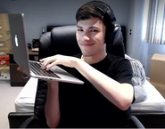 George holding his laptop.