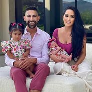 Dhar and Laura holding their two daughters Ella Rose and Myla Sky.