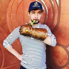 Jacksepticeye holding his drink with a Thanos Glove and an Avengers Infinity War Hat.