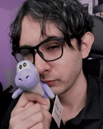 Danikyo sosteniendo un peluche de Yoshi color azul.
