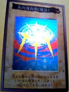 "Swords of Revealing Light", a Spell Card which has its property indicated right inside the name box, and a Bandai OCG promotional card