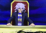 Yami Bakura am Spieltisch im Ultimativen Spiel der Schatten nachdem er auf dem Spielfeld zu Staub verfallen ist