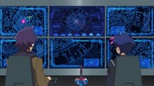 Kolter y Yusaku observando el esquema del ordenador madre