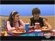 Quinn and Logan sit next to each other at the lunch table.